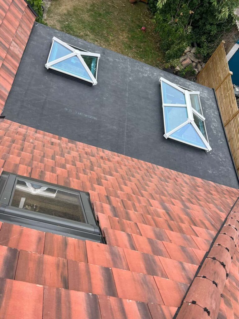 This is a photo taken from the roof ridge looking down a tiled pitched roof on to a flat roof. Works carried out by TRP Roofing Kirk Ella